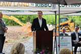 Congressman Brian Jack standing at a podium and addressing a crowd at the groundbreaking ceremony for the new Griffin-Spalding Regional Airport